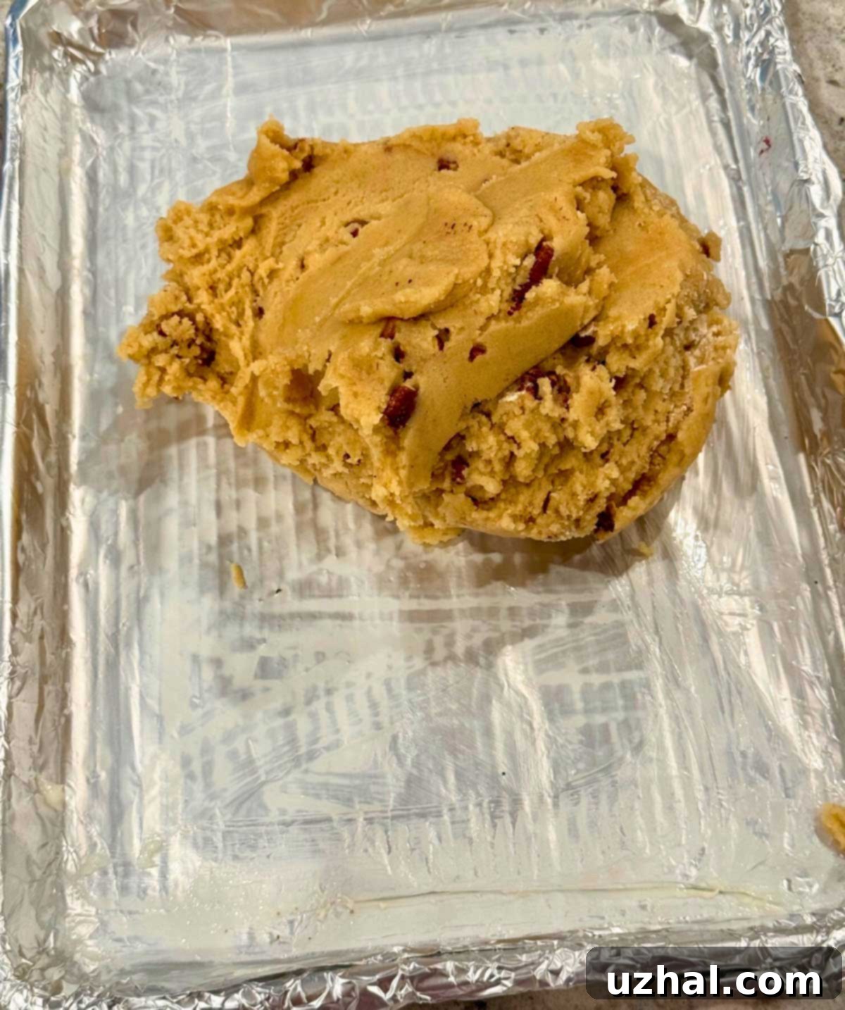 Brown Butter Maple Pecan Blondie Bars 4 Brown Butter Maple Pecan Bar cookie dough being pressed into a foil-lined 9x13 inch pan.