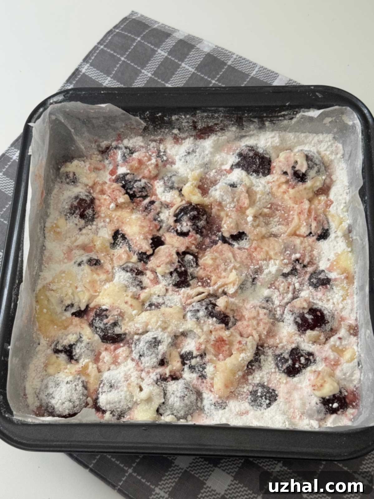 An unbaked Cha-Cha-Cha Cherry Cake in a square pan.
